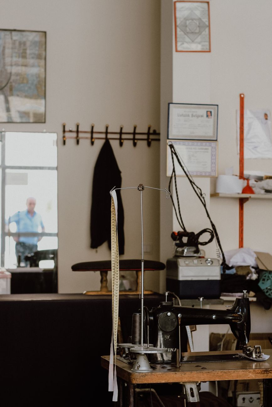 A vintage sewing machine in a tailor workspace; representative photography